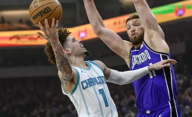 Charlotte Hornets guard LaMelo Ball (1) looks to shoot over Sacramento Kings forward Domantas Sabonis (11) during the first half of an NBA basketball game in Sacramento, Calif., Monday, Feb. 24, 2025. (AP Photo/Randall Benton)