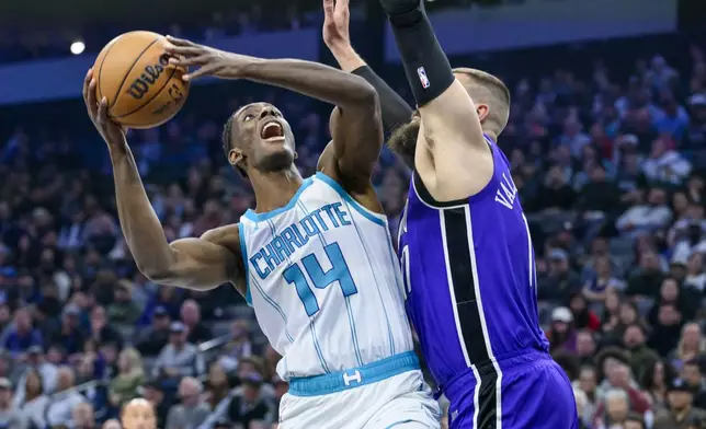 Charlotte Hornets forward Moussa Diabate (14) looks to shoot over Sacramento Kings center Jonas Valanciunas, right, during the first half of an NBA basketball game in Sacramento, Calif., Monday, Feb. 24, 2025. (AP Photo/Randall Benton)