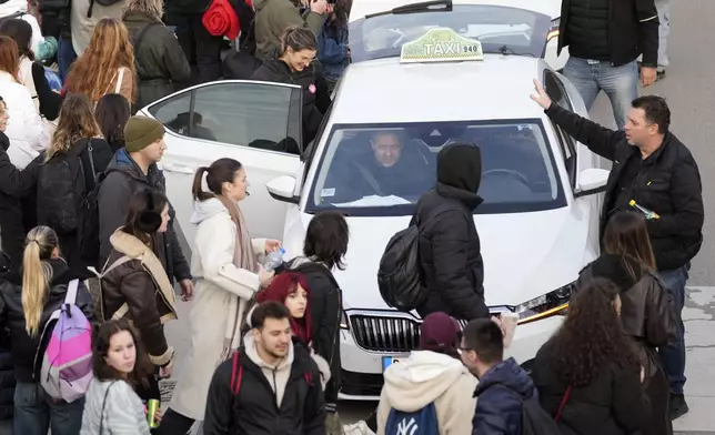 A taxi driver arrives to bring students back to Belgrade after a protest over the collapse of a concrete canopy that killed 15 people more than two months ago, in Novi Sad, Serbia, Sunday, Feb. 2, 2025. (AP Photo/Darko Vojinovic)