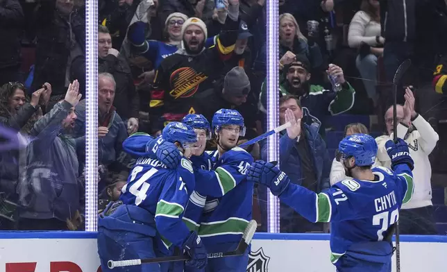 Vancouver Canucks' Jake DeBrusk, from left to right, Brock Boeser, Elias Pettersson and Filip Chytil celebrate Boeser's goal against the Colorado Avalanche during the third period of an NHL hockey game in Vancouver, British Columbia, Tuesday, Feb. 4, 2025. (Darryl Dyck/The Canadian Press via AP)