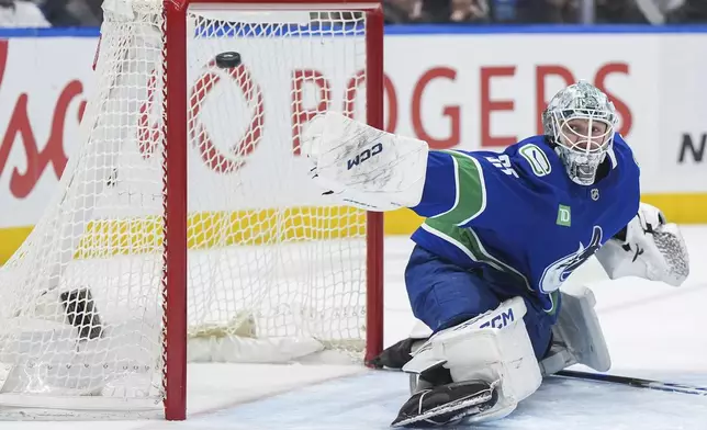 Vancouver Canucks goalie Thatcher Demko reaches across the net with his blocker as the puck goes wide of the goal during the second period of an NHL hockey game against the Colorado Avalanche, in Vancouver, on Tuesday, Feb. 4, 2025. (Darryl Dyck/The Canadian Press via AP)