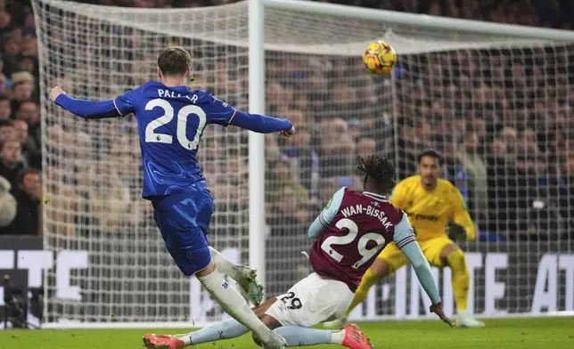 West Ham's Aaron Wan-Bissaka scores an own goal besides Chelsea's Cole Palmer during the English Premier League soccer match between Chelsea and West Ham United at Stamford Bridge stadium in London, Monday, Feb. 3, 2025. (AP Photo/Kirsty Wigglesworth)