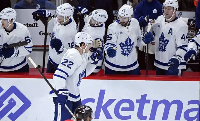 Toronto Maple Leafs defenseman Jake McCabe (22) celebrates with teammates after scoring against the Chicago Blackhawks during the second period of an NHL hockey game, Sunday, Feb. 23, 2025, in Chicago. (AP Photo/Matt Marton)
