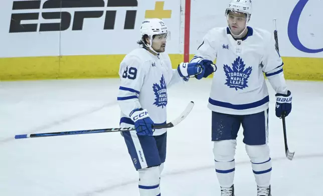 Toronto Maple Leafs left wing Nicholas Robertson (89) and center Max Domi (11) celebrate Robertson's goal against the Chicago Blackhawks during the second period of an NHL hockey game, Sunday, Feb. 23, 2025, in Chicago. (AP Photo/Matt Marton)