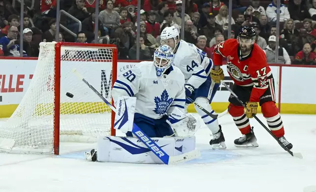 Toronto Maple Leafs goaltender Joseph Woll (60) defends against Chicago Blackhawks left wing Nick Foligno (17) as defenseman Morgan Rielly (44) looks on during the first period of an NHL hockey game, Sunday, Feb. 23, 2025, in Chicago. (AP Photo/Matt Marton)