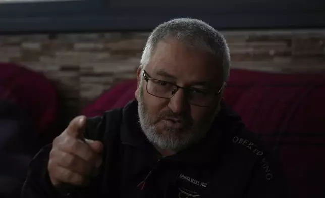Mohammed Shula speaks at a relative's house, where he and his wife have taken refuge, in the West Bank village of Kafr al-Labad, Monday, Feb. 10, 2025. (AP Photo/Nasser Nasser)