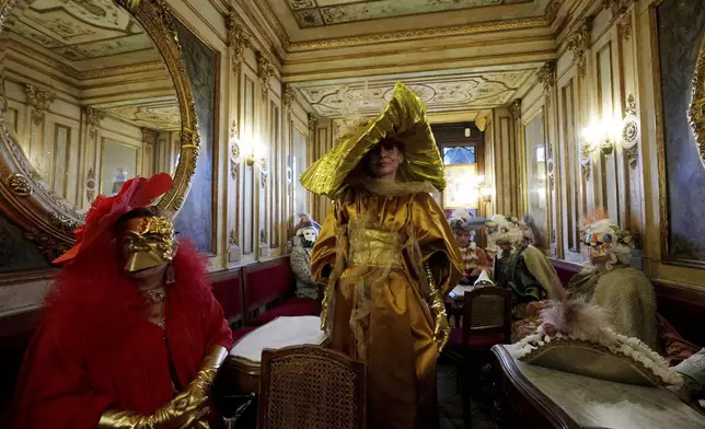Revellers participate in the celebrations of the historic Venetian Carnival, at the Florian Cafe' in St. Mark's Square, Venice, Italy, Sunday, Feb. 15, 2025. (AP Photo/Antonio Calanni)