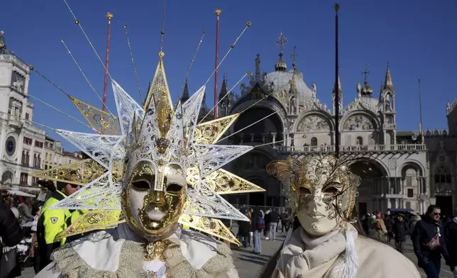 Revellers participate in the celebrations of the historic Venetian Carnival in front of St. Mark's Basilica in Venice, Italy, Saturday, Feb. 15, 2025. (AP Photo/Antonio Calanni)