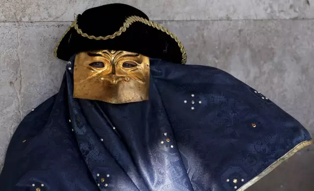 Revellers participating in the celebrations of the historic Venetian Carnival display their masks in Venice, Italy, Saturday, Feb. 15, 2025. (AP Photo/Antonio Calanni)