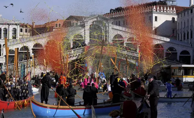Boats sail as confetti explodes in the air under the Rialto bridge during the traditional water parade, part of the historical Venice Carnival, in Venice, Italy, Sunday, Feb. 16, 2025. (AP Photo/Antonio Calanni)
