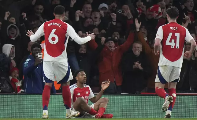 Arsenal's Myles Lewis-Skelly, bottom, celebrates scoring his side's 3rd goal during the English Premier League soccer match between Arsenal and Manchester City at the Emirates stadium in London, Sunday, Feb. 2, 2025. (AP Photo/Alastair Grant)