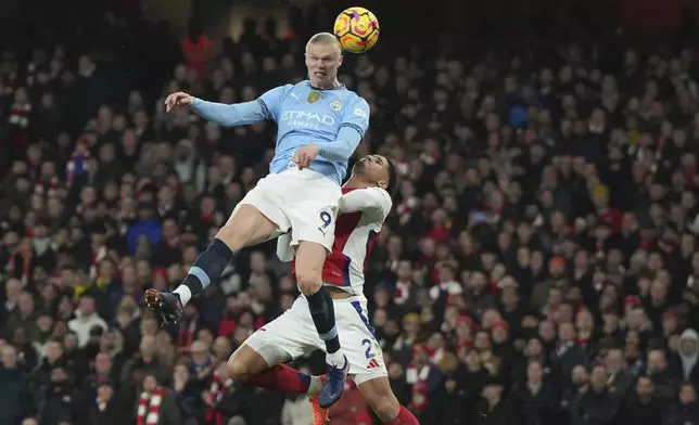 Manchester City's Erling Haaland, top, scores his side's first goal during the English Premier League soccer match between Arsenal and Manchester City at the Emirates stadium in London, Sunday, Feb. 2, 2025. (AP Photo/Alastair Grant)
