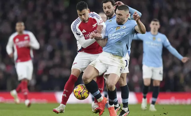 Manchester City's Mateo Kovacic, right, and Arsenal's Gabriel Martinelli fight for the ball during the English Premier League soccer match between Arsenal and Manchester City at the Emirates stadium in London, Sunday, Feb. 2, 2025. (AP Photo/Alastair Grant)