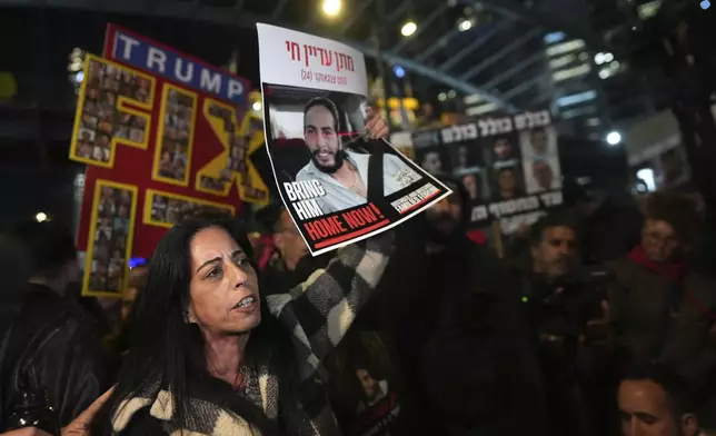 Einav Zangauker holds a poster of her son, Matan, who is held hostage by Hamas in the Gaza Strip, at a protest outside of Israel's Ministry of Defense in Tel Aviv, Israel, Monday, Feb. 10, 2025, after the militant group announced it would delay hostage releases in the Gaza Strip after accusing Israel of violating a fragile ceasefire. (AP Photo/Ohad Zwigenberg)