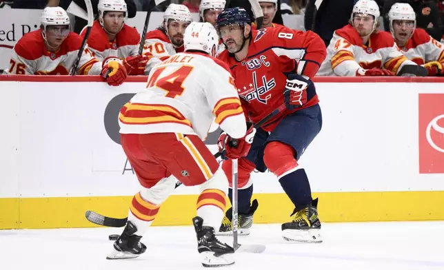Washington Capitals left wing Alex Ovechkin skates with the puck during the first period of an NHL hockey game against Calgary Flames defenseman Joel Hanley, Tuesday, Feb. 25, 2025, in Washington. (AP Photo/Nick Wass)