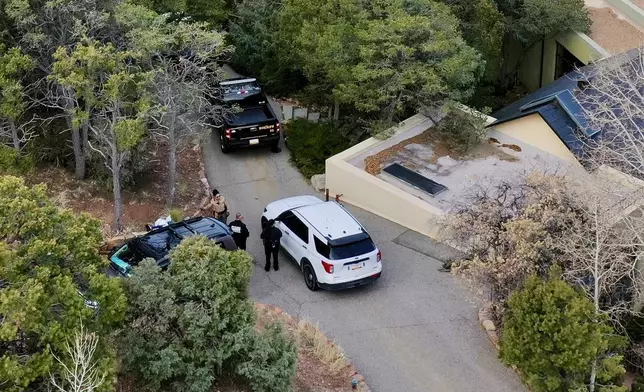 Law enforcement officials talk outside the home of actor Gene Hackman on Thursday, Feb. 27, 2025 in Santa Fe, New Mexico. Hackman, his wife Betsy Arakawa and their dog were found dead in the home a day earlier. (AP Photo/Roberto Rosales)