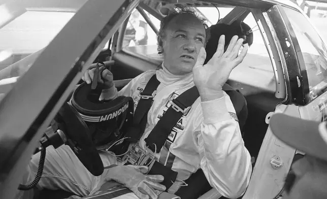 FILE - Actor Gene Hackman waves as he starts out for a practice run in his Toyota Celica, Feb. 5, 1983 at the Daytona International Speedway in preparation for the Daytona 24 Hour Endurac Race. This race marks the start of Hickman?s career as a professional driver. (AP Photo/Bob Self, File)