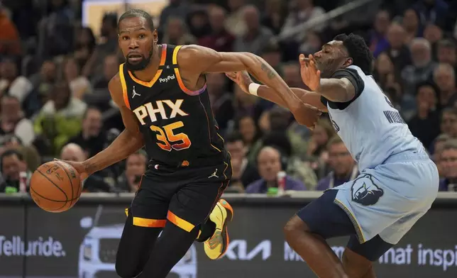 Phoenix Suns forward Kevin Durant (35) drives on Memphis Grizzlies guard Vince Williams Jr. during the first half of an NBA basketball game, Tuesday, Feb. 11, 2025, in Phoenix. (AP Photo/Rick Scuteri)