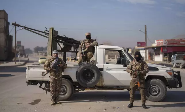 Members of the Syrian Democratic Forces pose for a portrait at a checkpoint in the northeastern city of Hassakeh, Friday, Jan. 31, 2025. (AP Photo/Bernat Armangue)