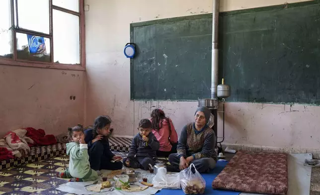 Internally displaced woman Elham Horo, right, and her family take shelter at an old school in the northeastern Syrian city of Qamishli, which is controlled by the U.S.-backed, Kurdish-led Syrian Democratic Forces, Tuesday, Jan. 28, 2025. (AP Photo/Bernat Armangue)