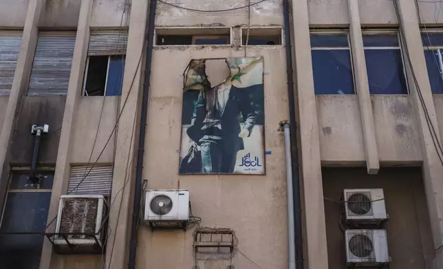 A damaged poster of ousted Syrian President Bashar Assad hangs on the facade of a building in the northeastern Syrian city of Qamishli, which is controlled by the U.S.-backed, Kurdish-led Syrian Democratic Forces, on Tuesday, Jan. 28, 2025. (AP Photo/Bernat Armangue)