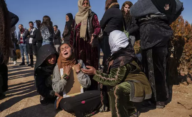 Women comfort a relative of Ibrahim al-Hamad, who was killed by a Turkish-backed militia, during the funeral of four Syrian Democratic Forces fighters in northeastern the village of Daoudiya, Wednesday, Jan. 29, 2025. (AP Photo/Bernat Armangue)