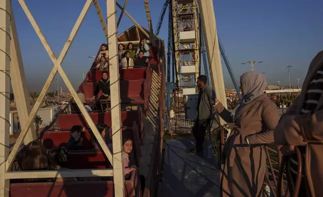 Families enjoy an amusement park in the northeastern Syrian city of Qamishli, which is controlled by the US-backed and Kurdish-led Syrian Democratic Forces, Saturday, Feb. 1, 2025. (AP Photo/Bernat Armangue)