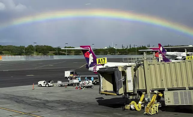 In this image taken through a window, a rainbow appears in the sky on Dec. 23, 2023, in Honolulu. (AP Photo/Audrey McAvoy)