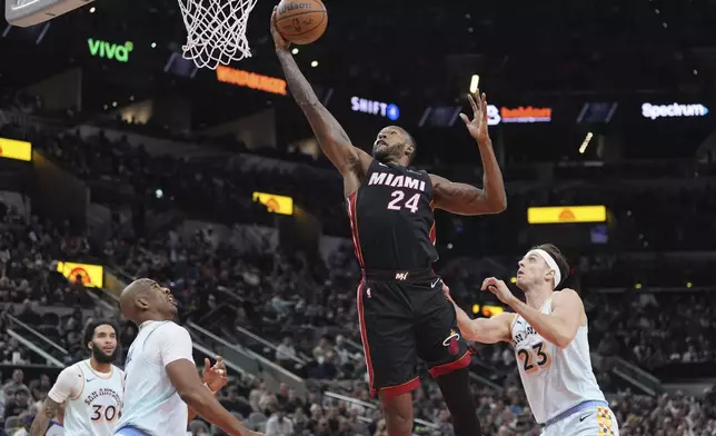 Miami Heat forward Haywood Highsmith (24) drives to the basket past San Antonio Spurs forward Zach Collins (23) during the first half of an NBA basketball game in San Antonio, Saturday, Feb. 1, 2025. (AP Photo/Eric Gay)