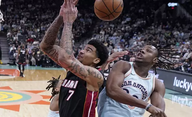 Miami Heat center Kel'el Ware (7) and San Antonio Spurs center Charles Bassey (28) reach for a rebound during the first half of an NBA basketball game in San Antonio, Saturday, Feb. 1, 2025. (AP Photo/Eric Gay)