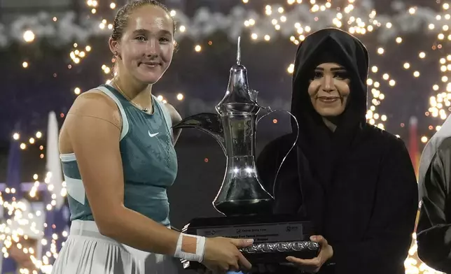 Russia's Mirra Andreeva is presented the winner's trophy by Sheikha Latifa after the Dubai Duty-Free Tennis Championship final match in Dubai, United Arab Emirates, on Saturday, Feb. 22, 2025. (AP Photo/Altaf Qadri)