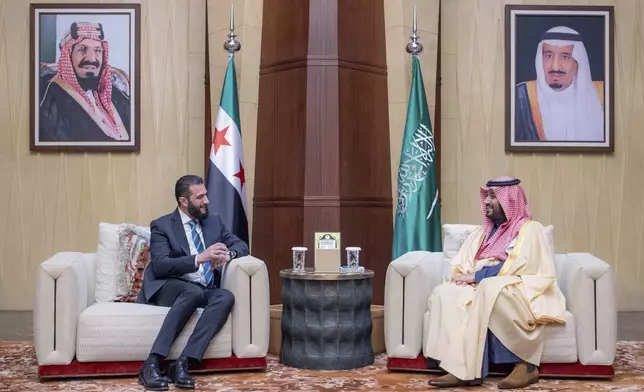 In this photo provided by the Saudi Ministry of Media, Saudi Crown Prince Mohammed bin Salman, right, meets with Syria's interim President Ahmad al-Sharaa, at the royal palace in Riyadh, Saudi Arabia, Sunday, Feb. 2, 2025. Portraits in the background show Saudi King Salman, right, and Saudi Arabia's founder late King Abdul Aziz Al Saud. (Saudi Ministry of Media via AP)