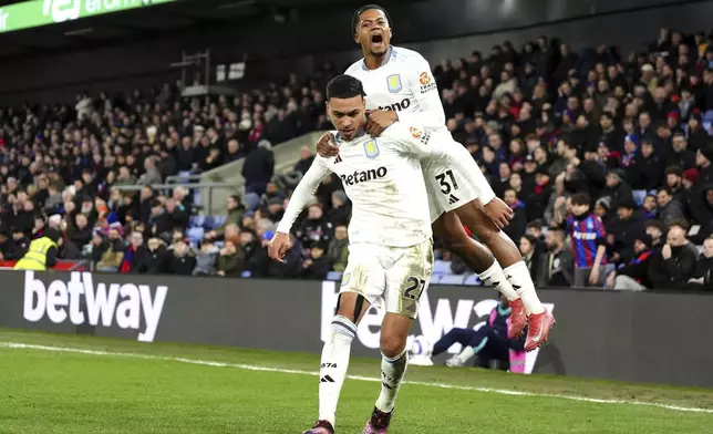 Aston Villa's Morgan Rogers, left, celebrates scoring their side's first goal of the game with teammate Leon Bailey during the English Premier League soccer match between Crystal Palace and Aston Villa at Selhurst Park, London, Tuesday, Feb. 25, 2025. (Zac Goodwin/PA via AP)