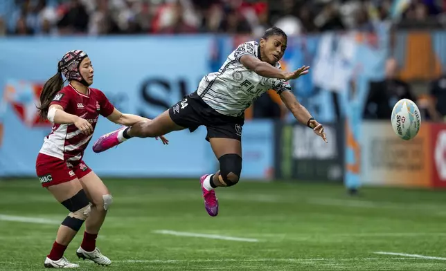 Fiji's Sera Bolatini vies for the ball as Japan's Suzuha Okamoto watches during a Vancouver Sevens semifinal rugby match in Vancouver, British Columbia, Sunday, Feb. 23, 2025. (Ethan Cairns/The Canadian Press via AP)