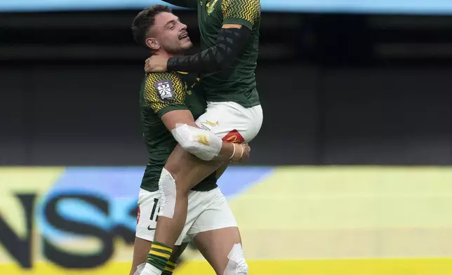 South Africa's Donavan Don celebrates with David Brits after defeating Fiji during a Vancouver Sevens semifinal rugby match in Vancouver, British Columbia, Sunday, Feb. 23, 2025. (Ethan Cairns/The Canadian Press via AP)