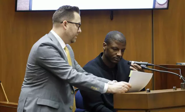 Los Angeles County Deputy District Attorney Paul Przelomiec, left, shows a document to A$AP Relli during A$AP Rocky's trial at the Clara Shortridge Foltz Criminal Justice Center in Los Angeles, Wednesday, Jan. 29, 2025. (Frazer Harrison/Pool via AP)