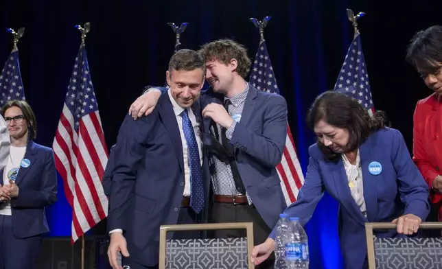 Newly elected Democratic National Committee Chairman Ken Martinfrom left, is hugged by his son Sam after winning the vote at the Democratic National Committee Winter Meeting at the Gaylord National Resort and Convention Center in National Harbor, Md., Saturday, Feb. 1, 2025. (AP Photo/Rod Lamkey, Jr.)