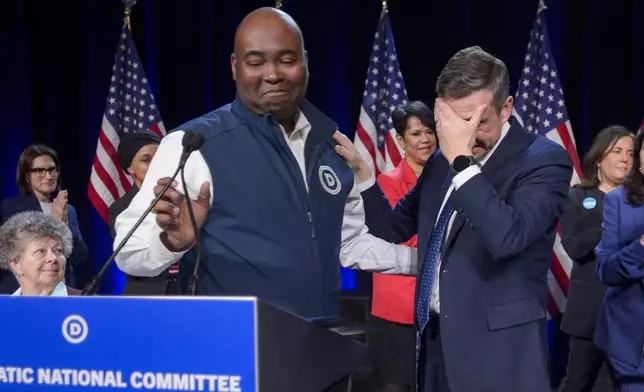 Former Democratic National Committee Chairman Jamie Harrison, left, stands next to newly elected DNC Chairman Ken Martin, right, as Martin reacts after winning the vote at the Democratic National Committee Winter Meeting at the Gaylord National Resort and Convention Center in National Harbor, Md., Saturday, Feb. 1, 2025. (AP Photo/Rod Lamkey, Jr.)