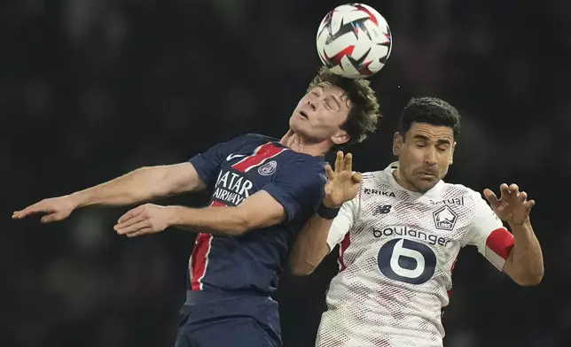 PSG's Joao Neves, left, and Lille's Benjamin Andre challenge the ball during the French League One soccer match between Paris Saint-Germain and Lille, Saturday, March 1, 2025 at the Parc des Princes stadium in Paris. (AP Photo/Christophe Ena)