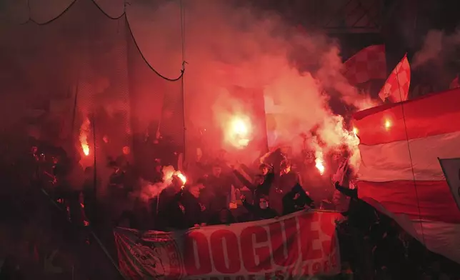 PSG supporters burn flares during the French League One soccer match between Paris Saint-Germain and Lille, Saturday, March 1, 2025 at the Parc des Princes stadium in Paris. (AP Photo/Christophe Ena)