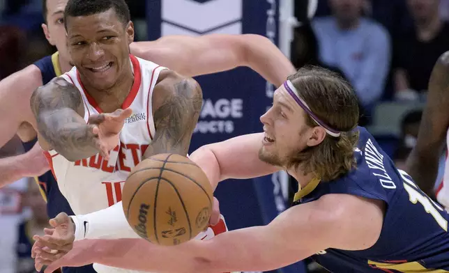 Houston Rockets forward Jabari Smith Jr., front left, and New Orleans Pelicans forward Kelly Olynyk, right, become entangled during the first half of an NBA basketball game in New Orleans, Thursday, March 6, 2025. (AP Photo/Matthew Hinton)
