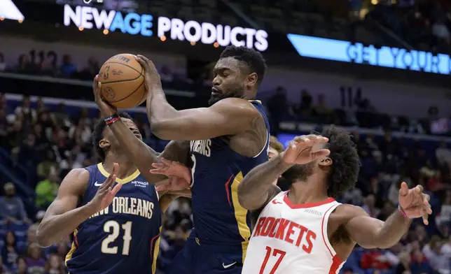 New Orleans Pelicans forward Zion Williamson (1) grabs a rebound next to Houston Rockets forward Tari Eason (17) during the first half of an NBA basketball game in New Orleans, Thursday, March 6, 2025. (AP Photo/Matthew Hinton)