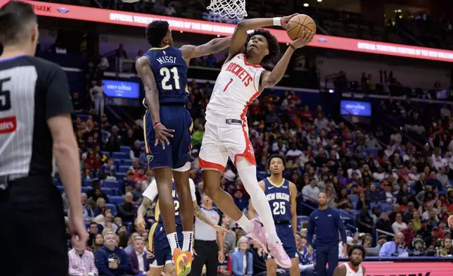 Houston Rockets forward Amen Thompson (1) gets around New Orleans Pelicans center Yves Missi (21) for a basket during the first half of an NBA basketball game in New Orleans, Thursday, March 6, 2025. (AP Photo/Matthew Hinton)