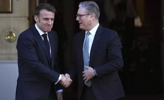 Britain's Prime Minister Keir Starmer, right, greets French President Emmanuel Macron as he arrives for a summit on Ukraine at Lancaster House in London, Sunday, March 2, 2025. (AP Photo/Christophe Ena, Pool)