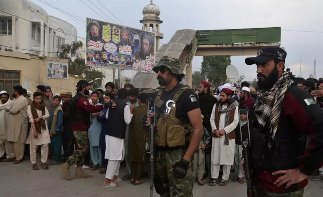 Police officers control crowd gather outside a pro-Taliban seminary 'Darul Uloom Haqqania' following a suicide bombing in a mosque, in Akora Khattak, a district in the Pakistan's northwestern Khyber Pakhtunkhwa province, Friday, Feb. 28, 2025. (AP Photo/Muhammad Sajjad)
