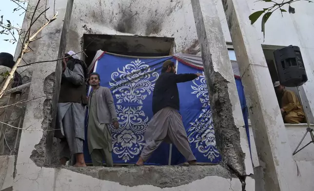 Mourners look at the site of Friday's suicide bombing following the funeral prayer of a senior Muslim cleric, Hamidul Haq, at a pro-Taliban seminary in Akora Khattak, Pakistan, Saturday, March 1, 2025. (AP Photo/Muhammad Sajjad)