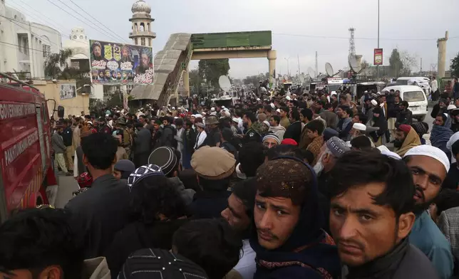 People gather outside a pro-Taliban seminary 'Darul Uloom Haqqania' following a suicide bombing in a mosque, in Akora Khattak, a district in the Pakistan's northwestern Khyber Pakhtunkhwa province, Friday, Feb. 28, 2025. (AP Photo/Muhammad Sajjad)