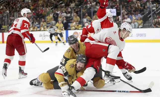 Vegas Golden Knights center Tomas Hertl (48) and Vegas Golden Knights left wing Pavel Dorofeyev (16) collide with Detroit Red Wings defenseman Simon Edvinsson (77) after a faceoff during the second period of an NHL hockey game Saturday, March 22, 2025, in Las Vegas. (AP Photo/Ian Maule)