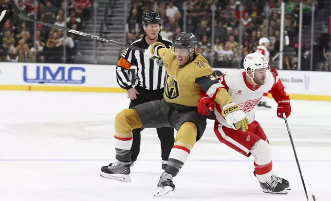Vegas Golden Knights defenseman Brayden McNabb (3) gets tangled up with Detroit Red Wings right wing Alex DeBrincat (93) during the first period of an NHL hockey game Saturday, March 22, 2025, in Las Vegas. (AP Photo/Ian Maule)