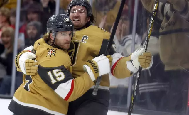 Vegas Golden Knights defenseman Noah Hanifin (15) and right wing Mark Stone (61) celebrate after Stone's goal during the second period of an NHL hockey game against the Detroit Red Wings, Saturday, March 22, 2025, in Las Vegas. (AP Photo/Ian Maule)